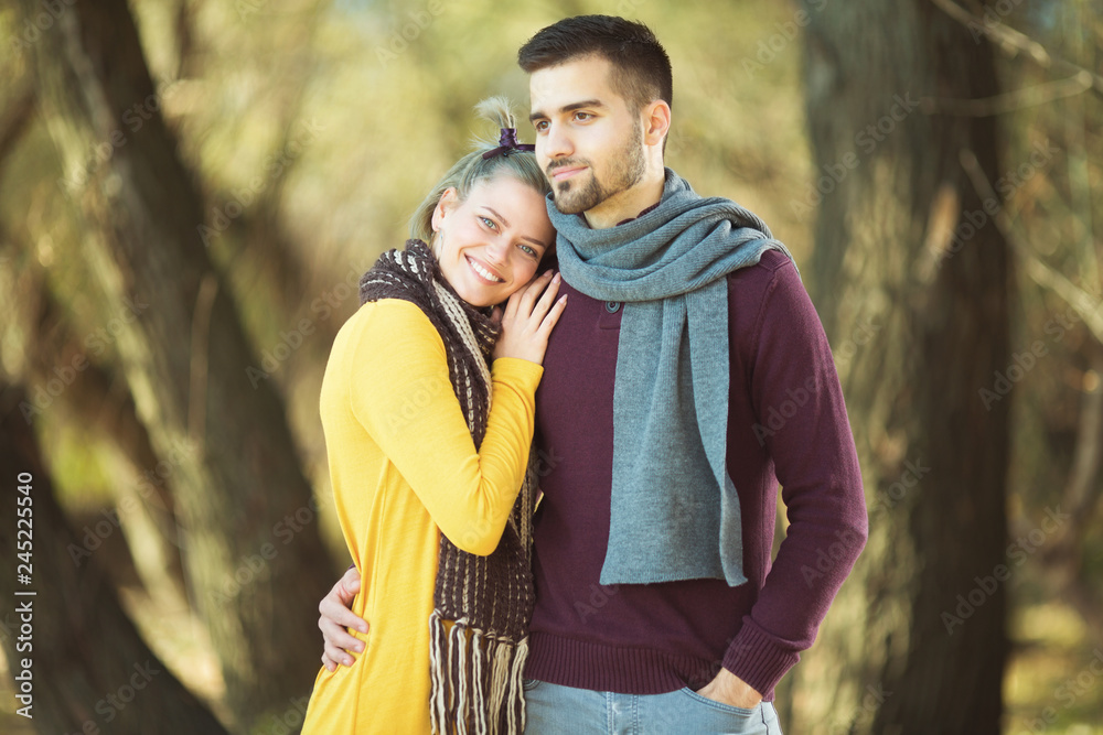 Young happy couple standing in front of camera in park Young happy couple standing in front of camera in park