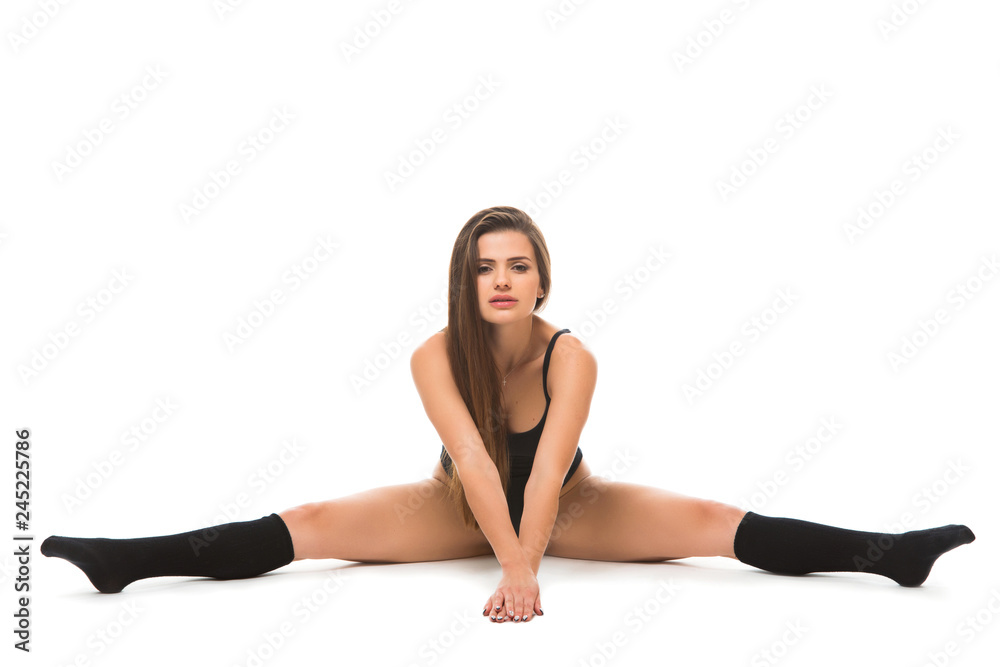 Young fitness woman wearing a sportswear doing stretching twine on the floor . Concept of healthy life