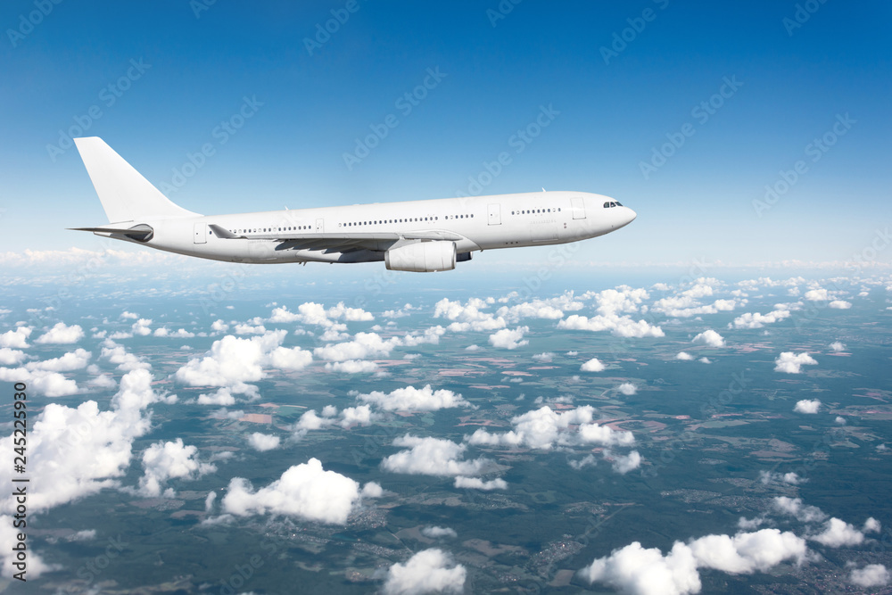 Fototapeta premium Samolot pasażerski lądujący przy dobrej pogodzie z chmurami błękitnego nieba na pasie startowym.