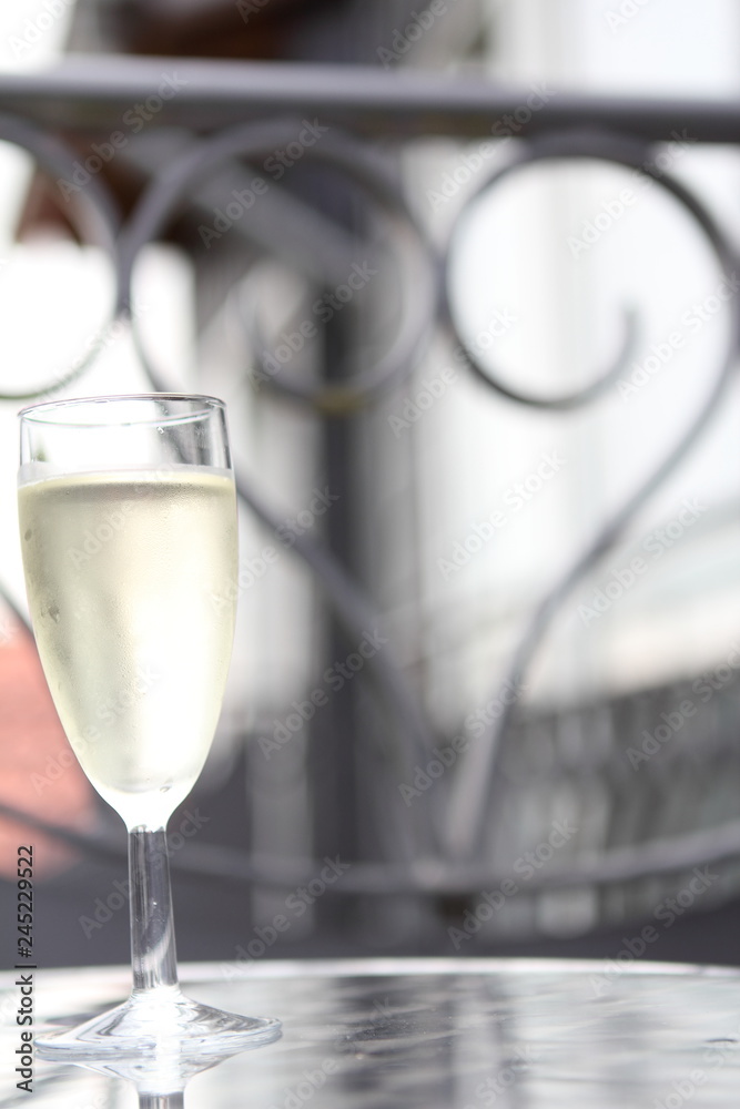 Die Liebe symbolisiert durch ein Herz am Balkon mit einem Glas Sekt