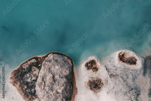 coast of the mineral lake, stones on the shore of the hydrogen sulfide lake