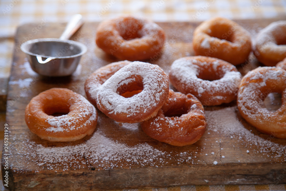 Homemade donuts with powdered sugar and chocolate on the wooden Homemade donuts with powdered sugar and chocolate on the wooden