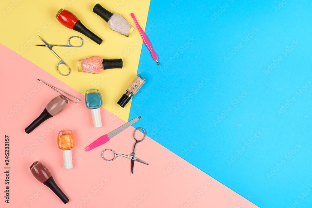  Nail polishes and tools for manicure on a colorful background