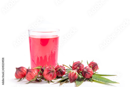 Fresh red roselle fruit and red water in glass isolated on white background.