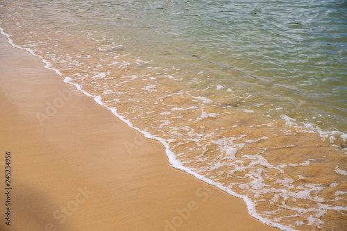 Sea water tide over yellow sand beach. Tropical seaside concept photo. Still seawater on sand beach.