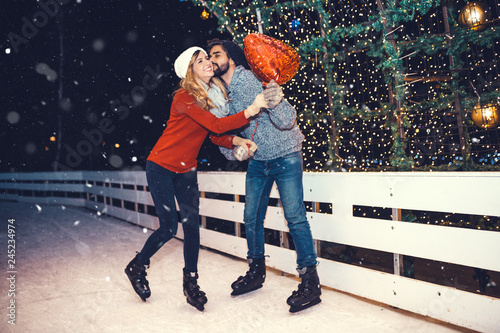 Happy romantic young couple enjoying together in ice skating.