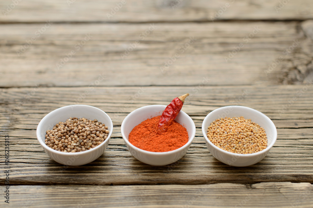 A set of spices on a wooden table. A set of spices on a wooden table.