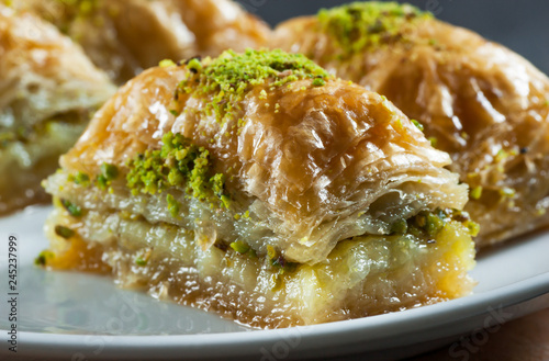 Traditional turkish dessert antep baklava with pistachio on white plate. Desserts concept photo