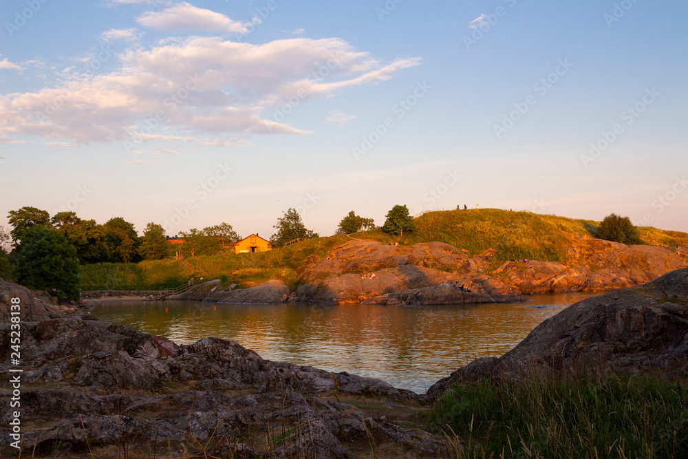 The rocky shore and bay of Suomenlinna Island in the Gulf of Finland is a beautiful traditional landscape of Finland, a summer evening in Finland.