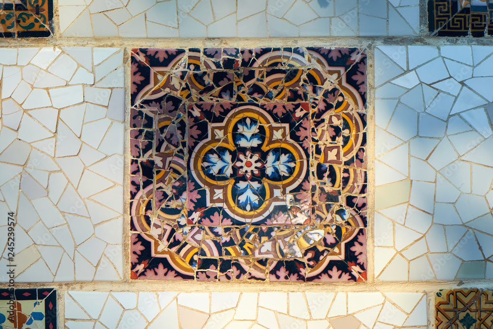 Trencadis technique decorative square ceramics on a wall in the Guell park