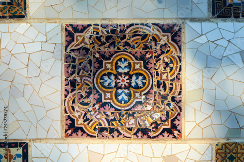 Trencadis technique decorative square ceramics on a wall in the Guell park