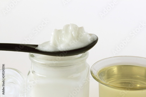 coconut oil in jar and spoon in white background