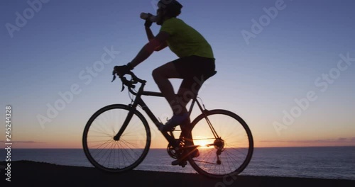 Wallpaper Mural Cyclist athlete man cycling biking training exercise and drinking water. Healthy active lifestyle sports fitness man exercising at sunset. SLOW MOTION RED Cinema Camera. Torontodigital.ca