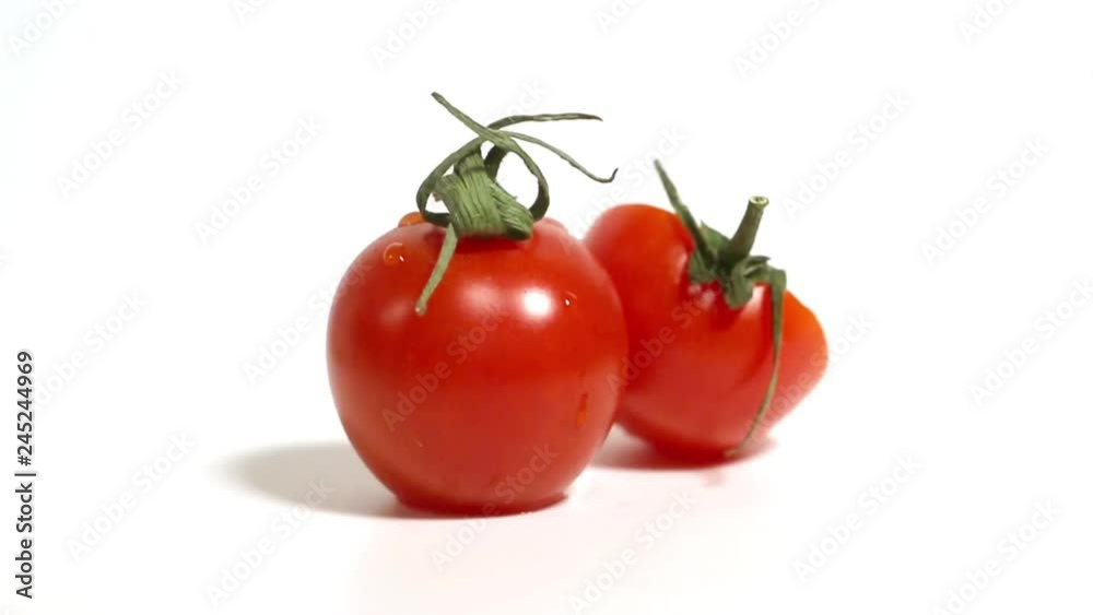 Red small tomatoes rotate on a white background. Red small tomatoes rotate on a white background.