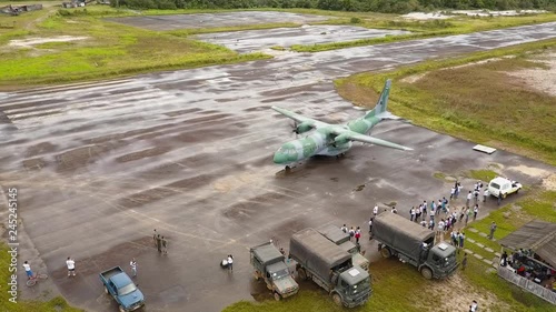 Aerial Drone Shot of Humanitarian Aide Workers Surrounding a Large Military Cargo Plane Before a Surgical Expedition in South America. photo