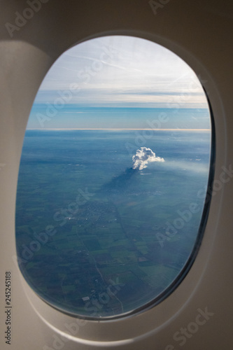 Smoke and steam of a power plant seen from airplane with shadow on ground