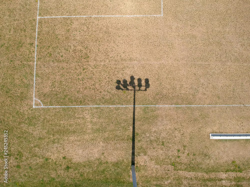 Stadium lights from behind at an sport arena stadium with green grass on summer sunny hot day. photo