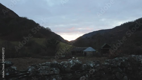 Slightly moving handheld shot looking at sunset in a trainglular mountain shape