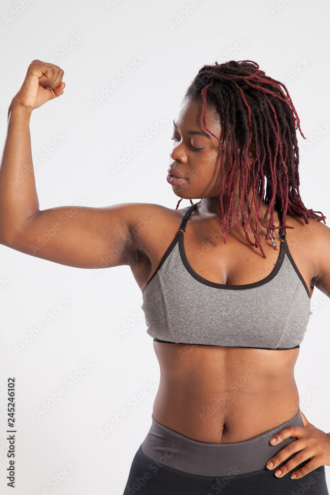 Strong Black woman flexing her muscle Stock Photo