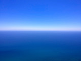 Blue lake water and sky, water scape with horizon and clear deep blue sky. Aerial background.
