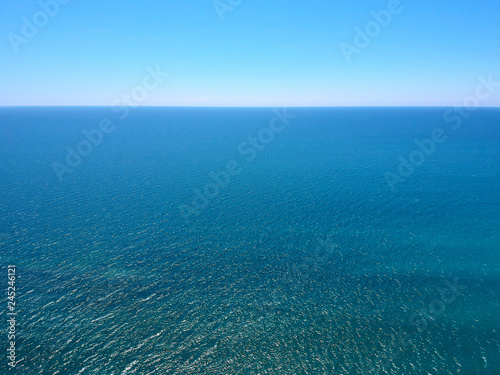 Seascape with sea horizon and clear deep blue sky. Horizontal vivid minimal landscape abstraction background backdrop. Get lost in a peaceful and misty ocean aerial view.