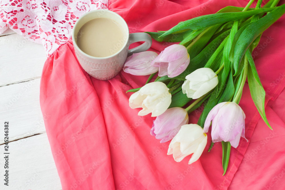 Bouquet of tulips with a mug of coffee and a gift in a red box on a pink cloth. International Women's Day, Valentine's Day, Mother's Day. Selective focus. Bouquet of tulips with a mug of coffee and a gift in a red box on a pink cloth. International Women's Day, Valentine's Day, Mother's Day. Selective focus.