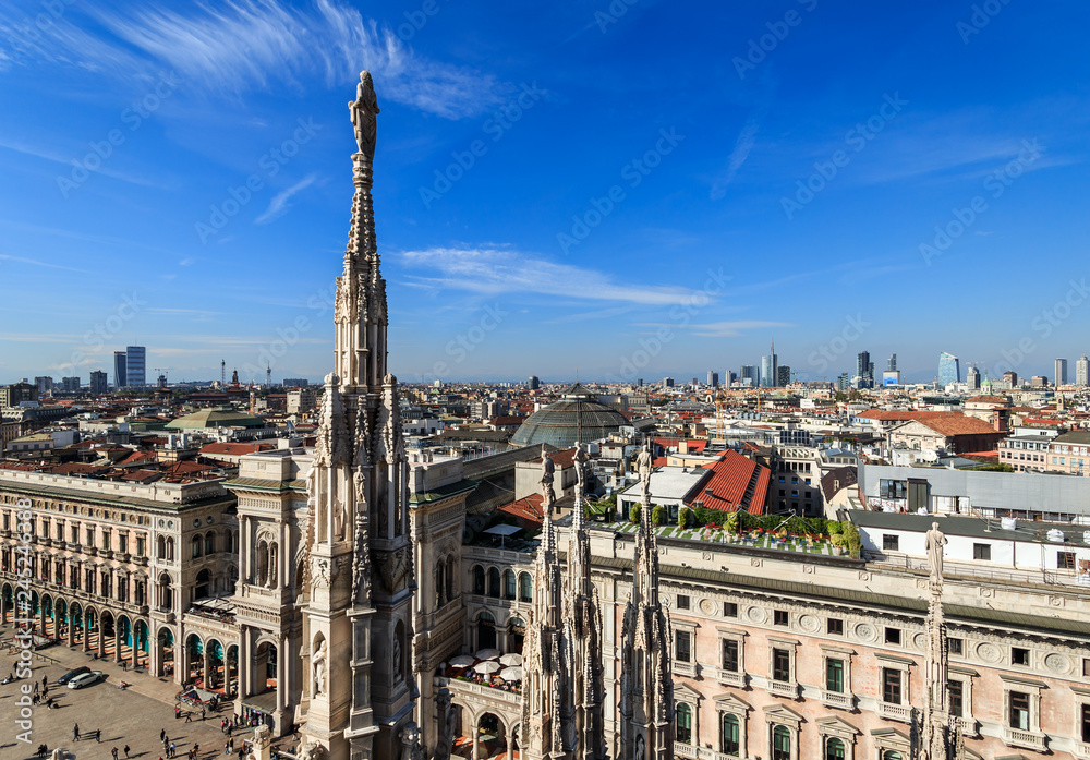 Top view from the roof of Duomo di Milano Cathedral with marble statues to the city and Galleria Vittorio Emanuele II on Piazza del Duomo square. Milan, Italy.