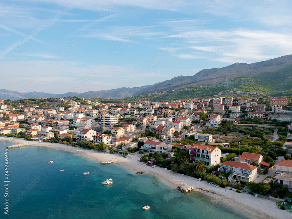 Scenic aerial bird view at morning coastal village near Split in Croatia, calm and quite tourist vocational hotel seafront under green mountains in Europe. 360 panoramic photography.