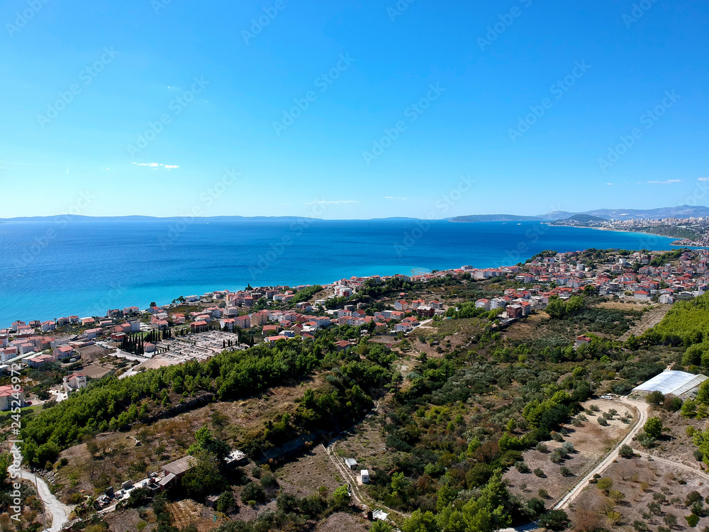 Aerial panoramic view of European village near Split. Green mountains local's farms and vegetation growing. Travel destination in Croatia.