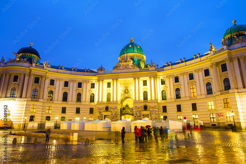 Illuminated Hofburg Palace seen from Michaelerplatz at night in Vienna, Austria