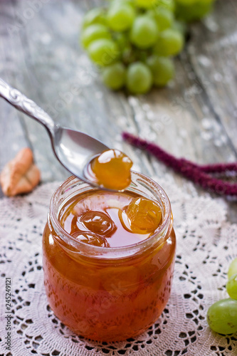 Slatko - white grape jam (sweet), traditional serbian desert; white grapes in syrup in a glass jar