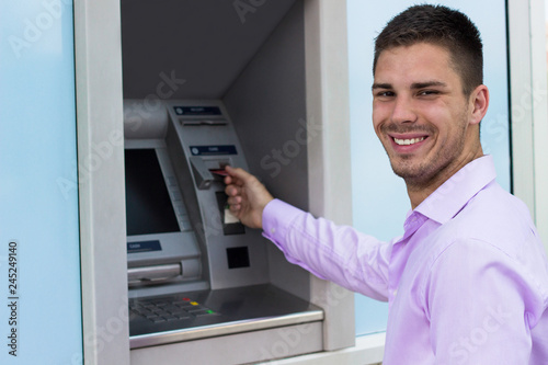 Young businessman withdrawing money from a cash machine