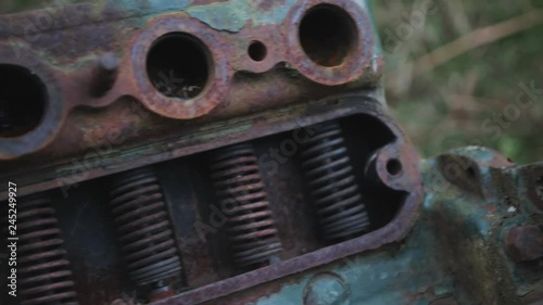 Panning shot of a green old rusty engine outside