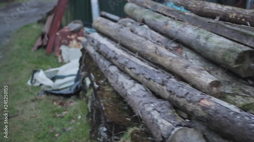 Moving shot of junkyard items, rusty old metal, rope and tree logs