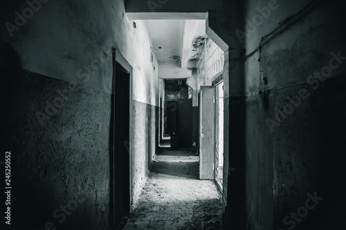 Long corridor with doors in haunted and ruined abandoned industrial building