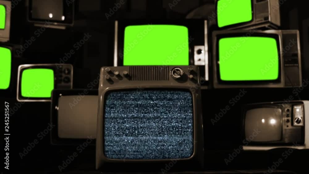 Piled Retro TVs with Flickering Green Chroma Screens. Sepia Tone. Zoom