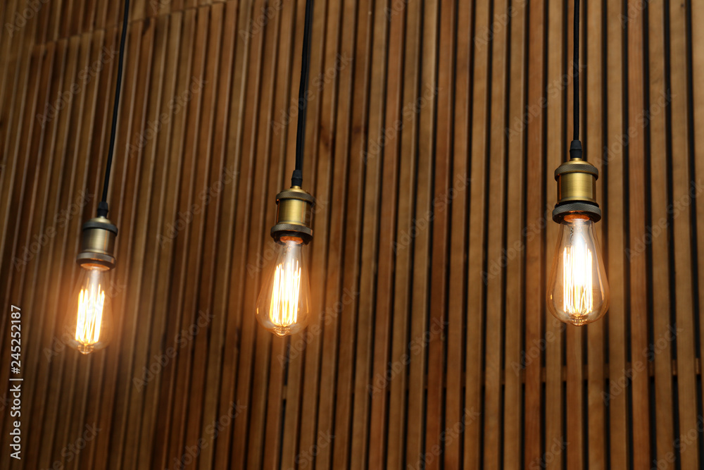 Pendant lamps with light bulbs on wooden background Pendant lamps with light bulbs on wooden background
