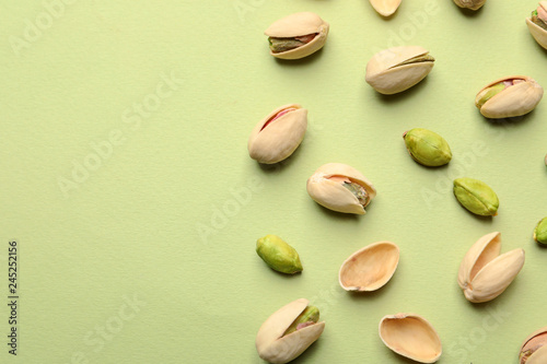 Organic pistachio nuts on color background, flat lay. Space for text