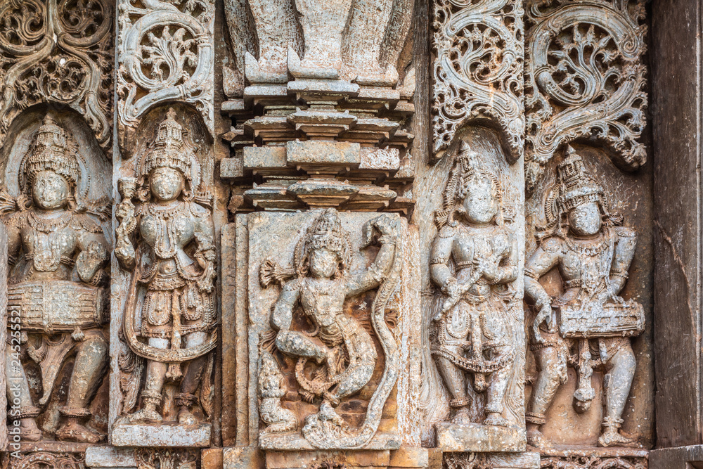 Belavadi, Karnataka, India - November 2, 2013: Veera Narayana Temple. Closeup of outside wall panel with nobility, dancing girl and musicians. All face taken off by Islamic conquerors.