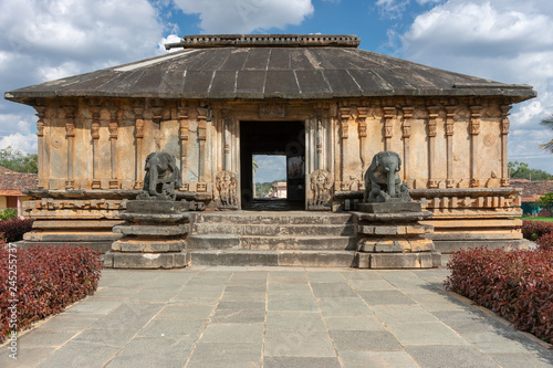 Belavadi, Karnataka, India - November 2, 2013: Veera Narayana Temple. Entrance hall, seen from the sanctuary, to the temple sturcture show two elephant statues and a pillared structure. Blue sky with  photo