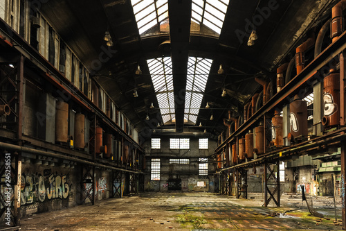 Symetric view of a abandoned and runied factory hall with glass roof