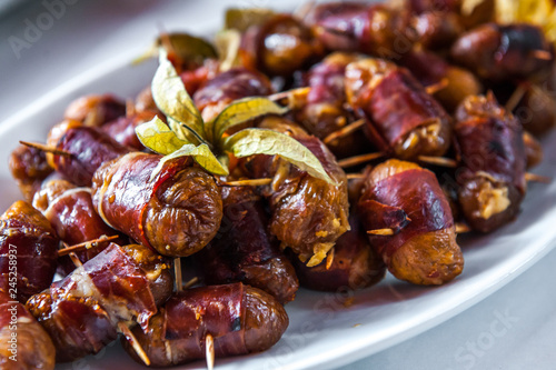 Date friut with bacon arranged on a white porcelain plate