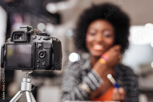 Cute african american woman with curly hair conducting fashion tutorial