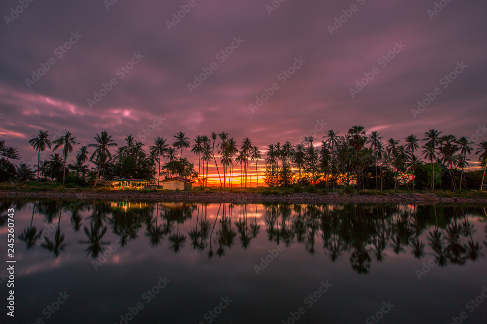 The background of the small house, the location of the beach, the beautiful morning light and the coconut trees, the sky according to the changes of the solar period 