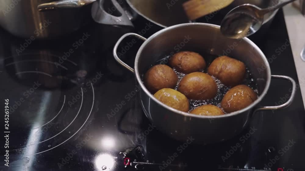Cooking donuts in the kitchen. Saucepan with boiling oil Cooking donuts in the kitchen. Saucepan with boiling oil