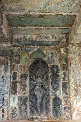 Belur, Karnataka, India - November 2, 2013: Chennakeshava Temple building. Wall under mandapam with multiple stone sculptures of intertwined snakes, symbol of Tamas, the destructive tendency, and a Na