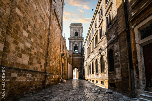A medieval bell tower with a tunnel opens up to the ancient Piazza del duomo in the historic center of Brindisi Italy.