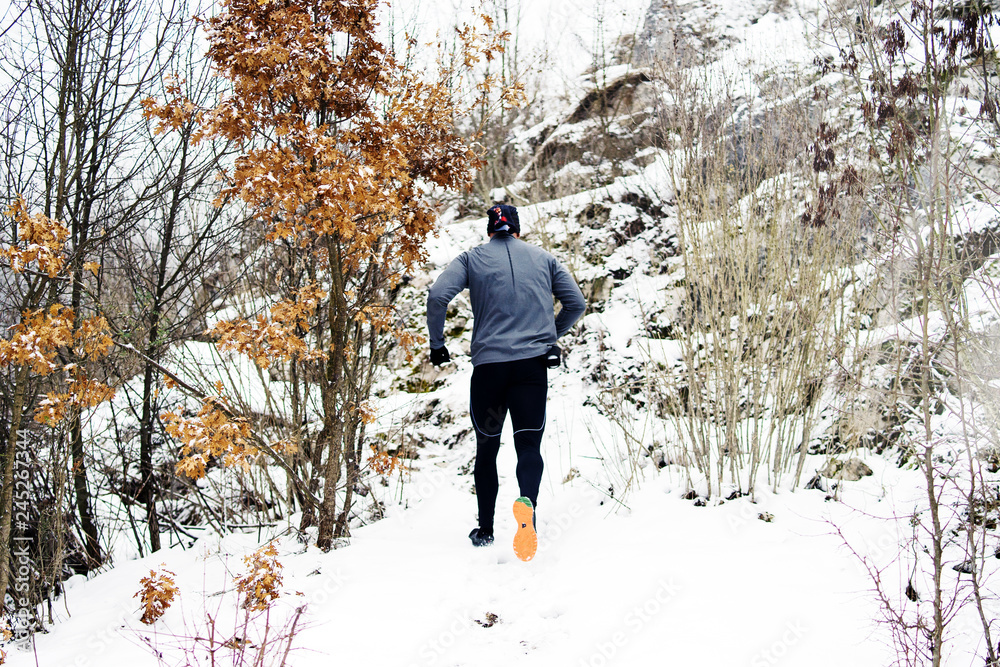 man running in winter forest