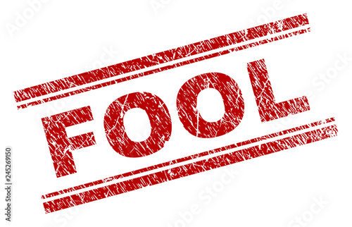 FOOL seal print with grunge texture. Red vector rubber print of FOOL text with scratched texture. Text label is placed between double parallel lines.