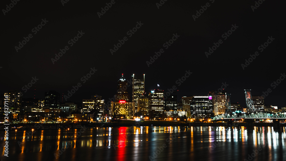 Nighttime Cityscape Across Water with Reflections